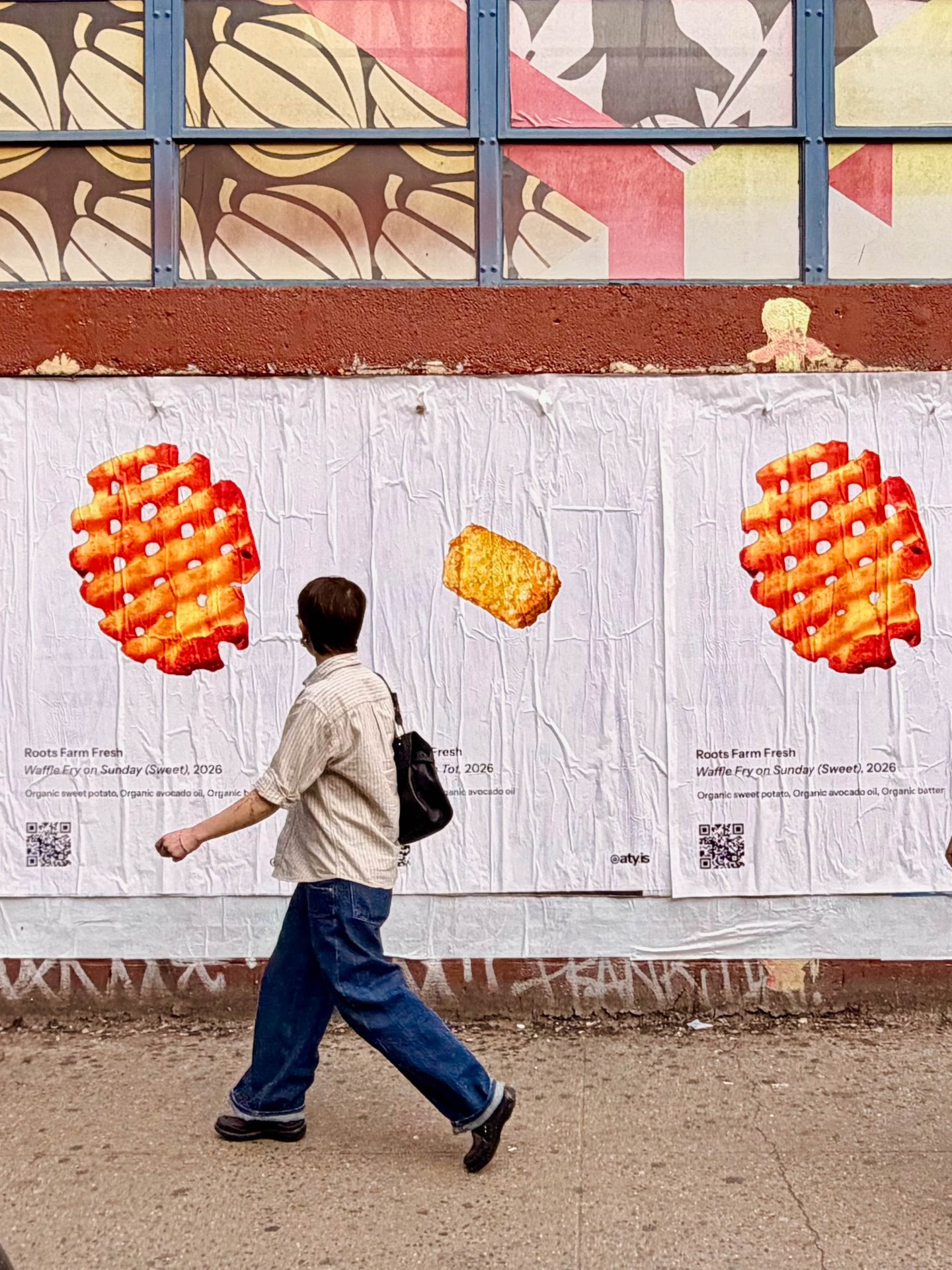 Pedestrian walking past Roots Farm Fresh posters